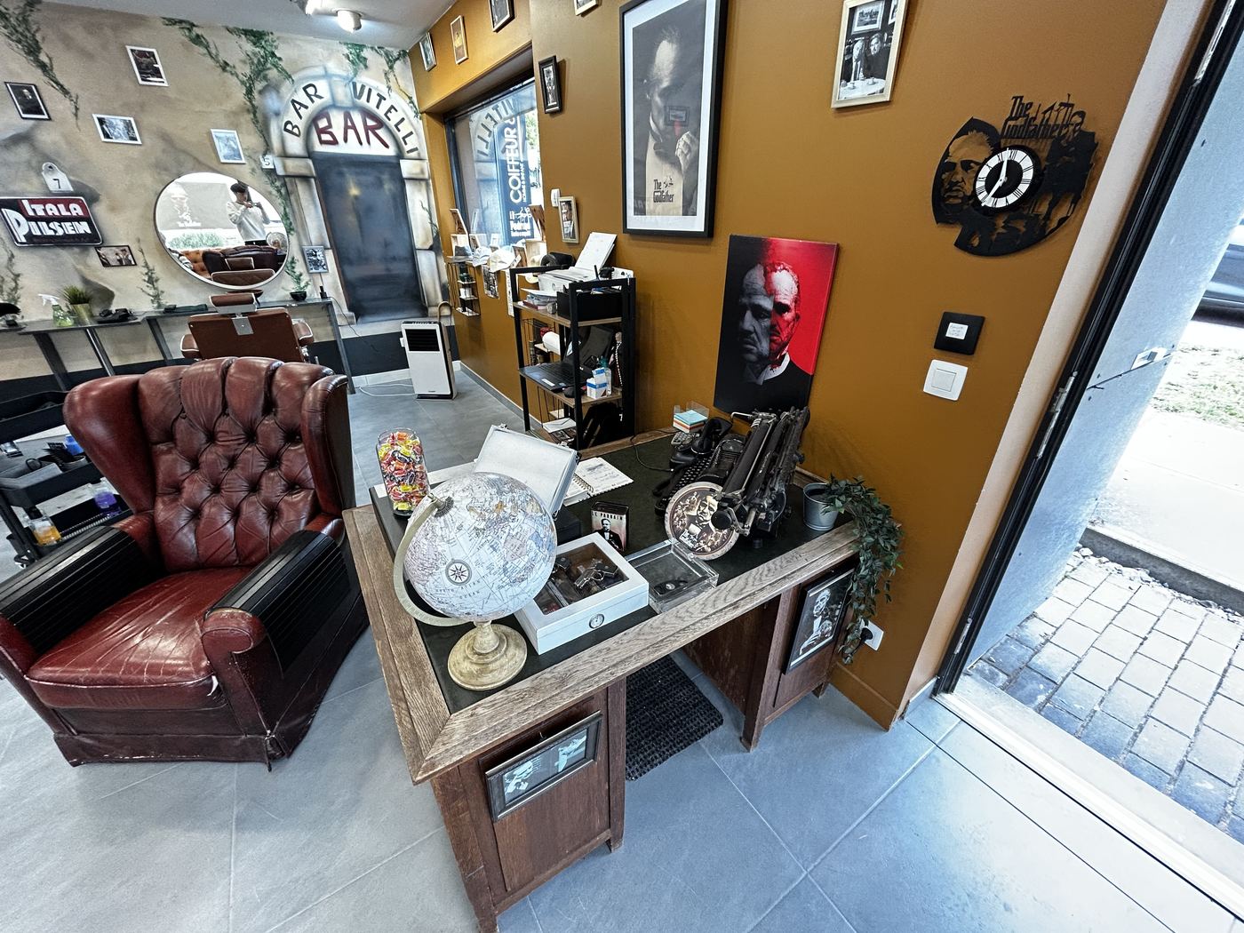 L'intérieur du salon Il Padrino : fauteuil Chesterfield en cuir et comptoir en bois