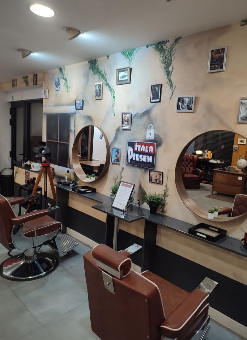 L'intérieur du salon Il Padrino : fauteuils de barbier en cuir, miroirs ronds et décor The Godfather